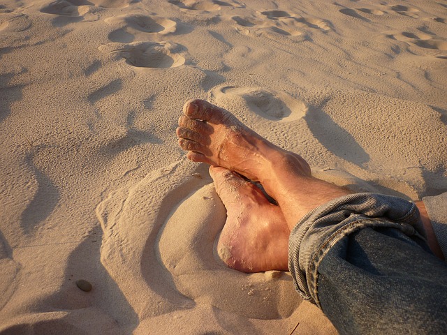Bosé nohy v piesku na pláži.jpg
